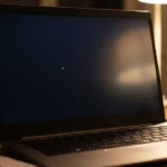 Laptop screen showing a small white spot against a dark background